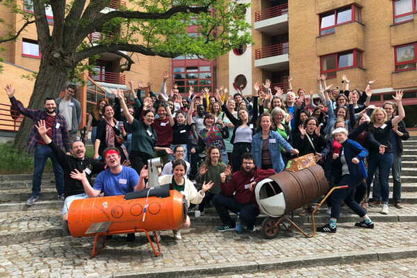 Gruppenbild mit rund 60 ijgdler*innen die in die Kamera winken